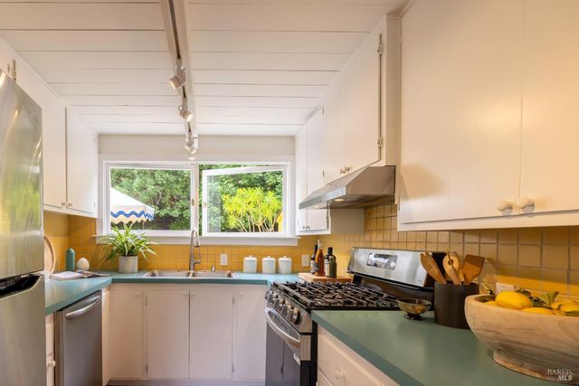 a kitchen with stainless steel appliances a sink a stove and a microwave