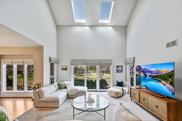 a kitchen with stainless steel appliances granite countertop a stove a sink dishwasher a refrigerator white cabinets and wooden floor next to a window