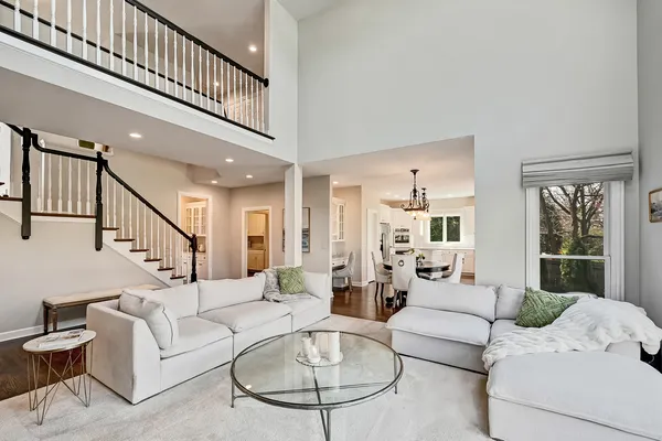 a kitchen with a stove a sink a dining table wooden floor and living room view