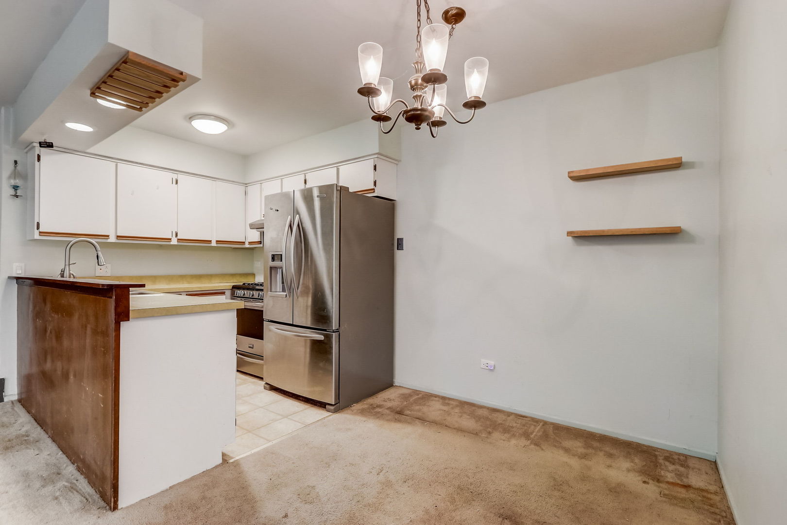 702 Inverrary Lane Deerfield, IL 60015 - Photo 8 of 46 a kitchen with stainless steel appliances a refrigerator and a chandelier