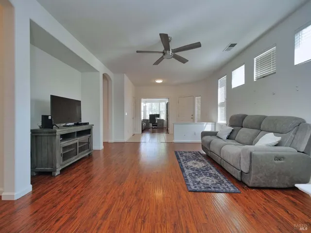 a living room with furniture and a wooden floor