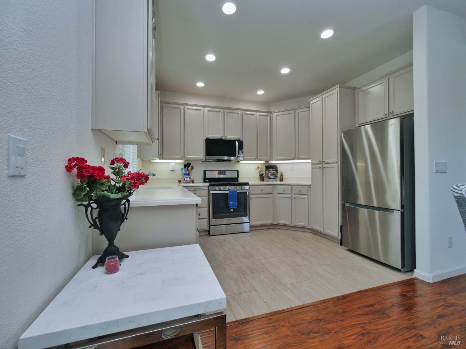 659 Pinehurst Drive, Unit CA Rio Vista, CA 94571 - Photo 7 of 40 a kitchen with kitchen island white cabinets a sink dishwasher and a refrigerator