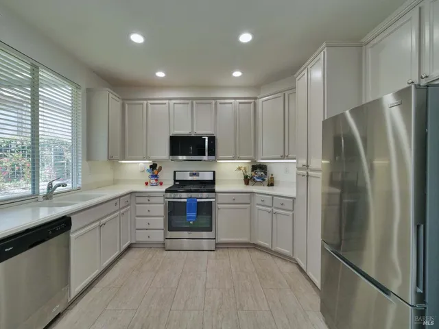 a kitchen with stainless steel appliances a refrigerator sink and microwave