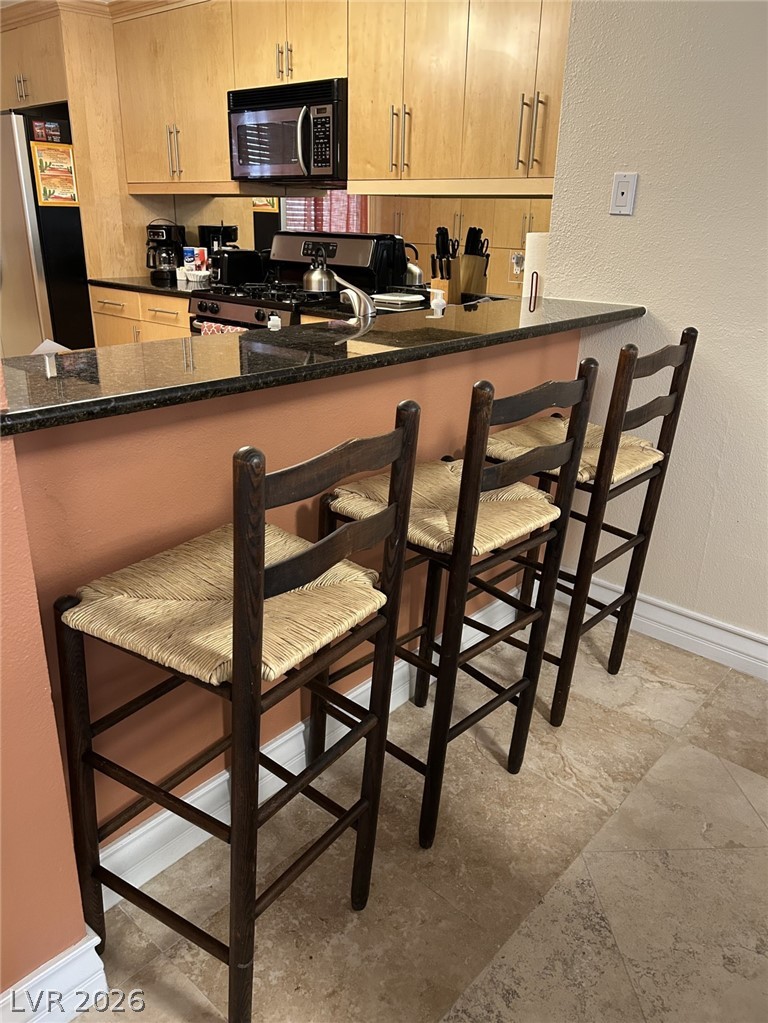 210 East Flamingo Road, Unit 137 Las Vegas, NV 89169 - Photo 8 of 32 A well-appointed kitchen offers ample counter space with bar seating and integrated appliances.