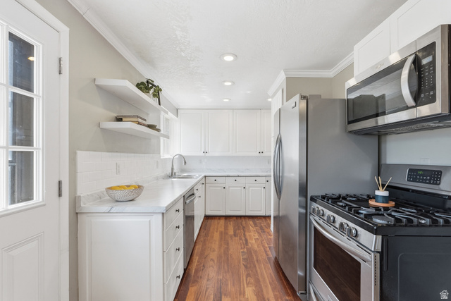 7795 South 1000 East Midvale, UT 84047 - Photo 42 of 42 Modern kitchen featuring white cabinetry, light countertops, wood-finish flooring, stainless steel appliances, and recessed lighting