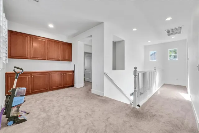 a view of an empty room with a cabinet and stairs