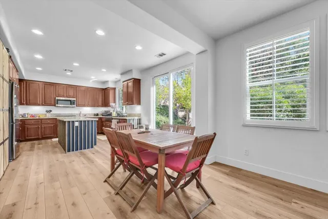 a kitchen with stainless steel appliances kitchen island granite countertop a sink table and chairs