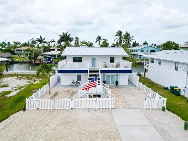 an aerial view of a house with swimming pool and furniture