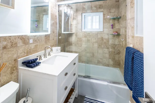 a bathroom with a sink a toilet and shower