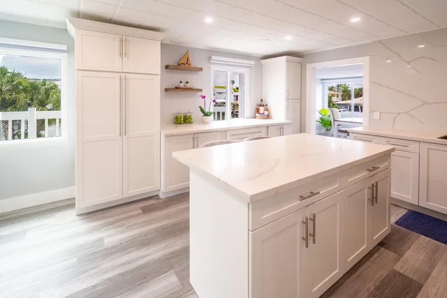 a kitchen with a sink a stove a refrigerator and white cabinets