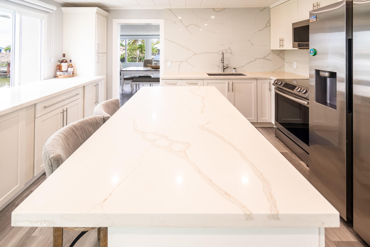 576 Coconut Avenue Goodland, FL 34140 - Photo 8 of 38 a large white kitchen with sink and stainless steel appliances