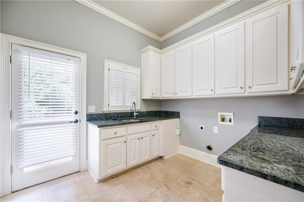 2760 Sugarloaf Club Drive Duluth, GA 30097 - Photo 25 of 67 a kitchen with granite countertop white cabinets and sink