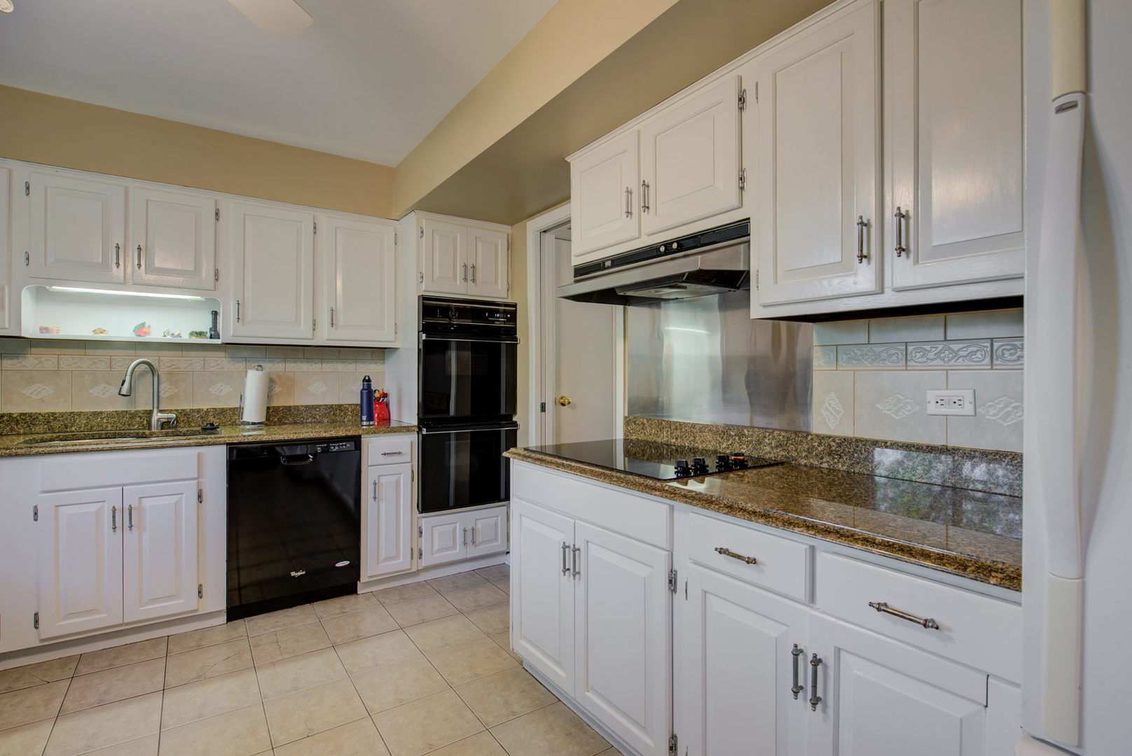 1251 Kenton Road Deerfield, IL 60015 - Photo 8 of 36 a kitchen with granite countertop white cabinets and stainless steel appliances