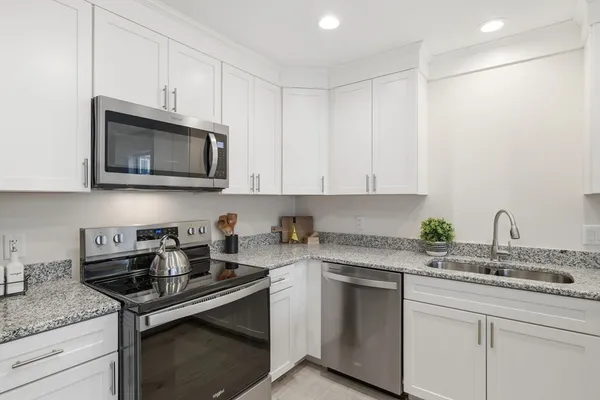 a kitchen with stainless steel appliances granite countertop a sink stove and microwave
