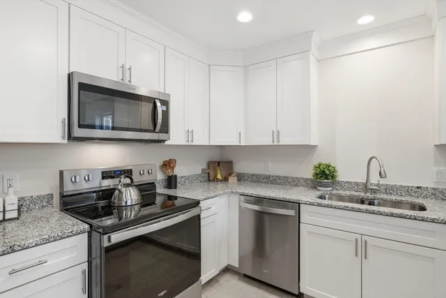 a kitchen with stainless steel appliances granite countertop a sink stove and microwave