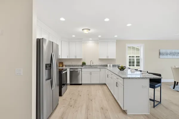 a kitchen with a sink a refrigerator and cabinets