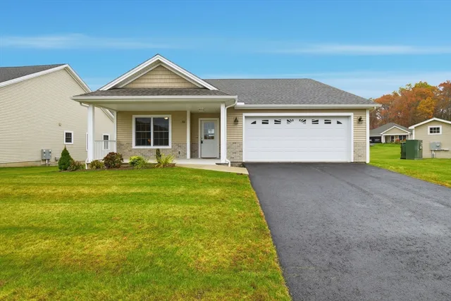 a front view of a house with a garden and plants