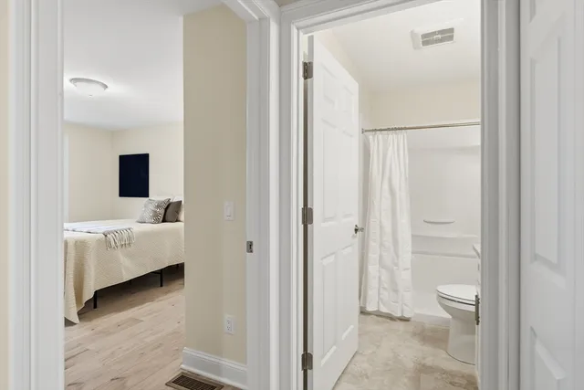 a en suite bathroom with a tub shower and a sink