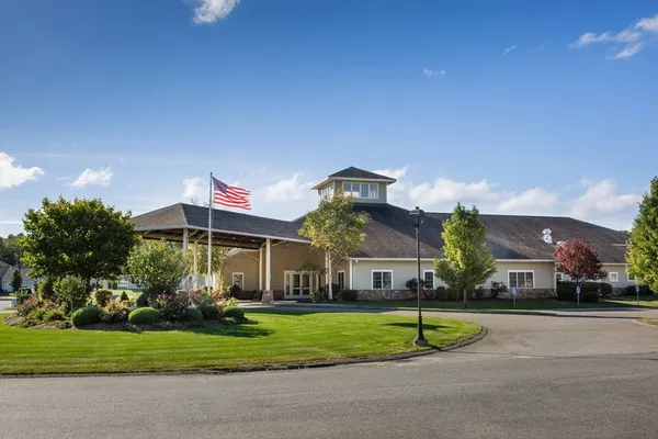 a front view of a house with a yard and potted plants
