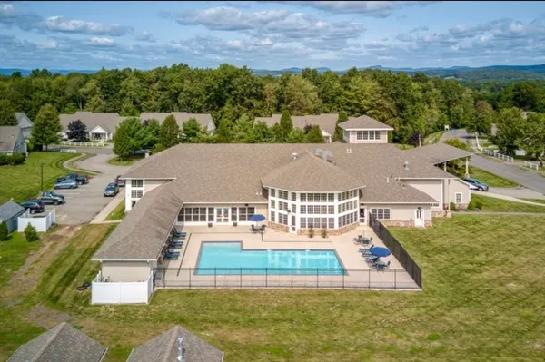 an aerial view of residential houses with outdoor space and trees
