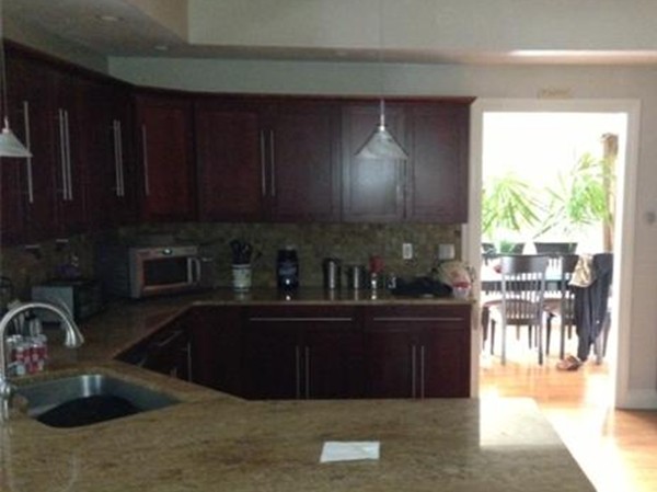 222 Perry Hill Road Acushnet, MA 02743 - Photo 4 of 13 a kitchen with granite countertop a sink a stove and wooden cabinets