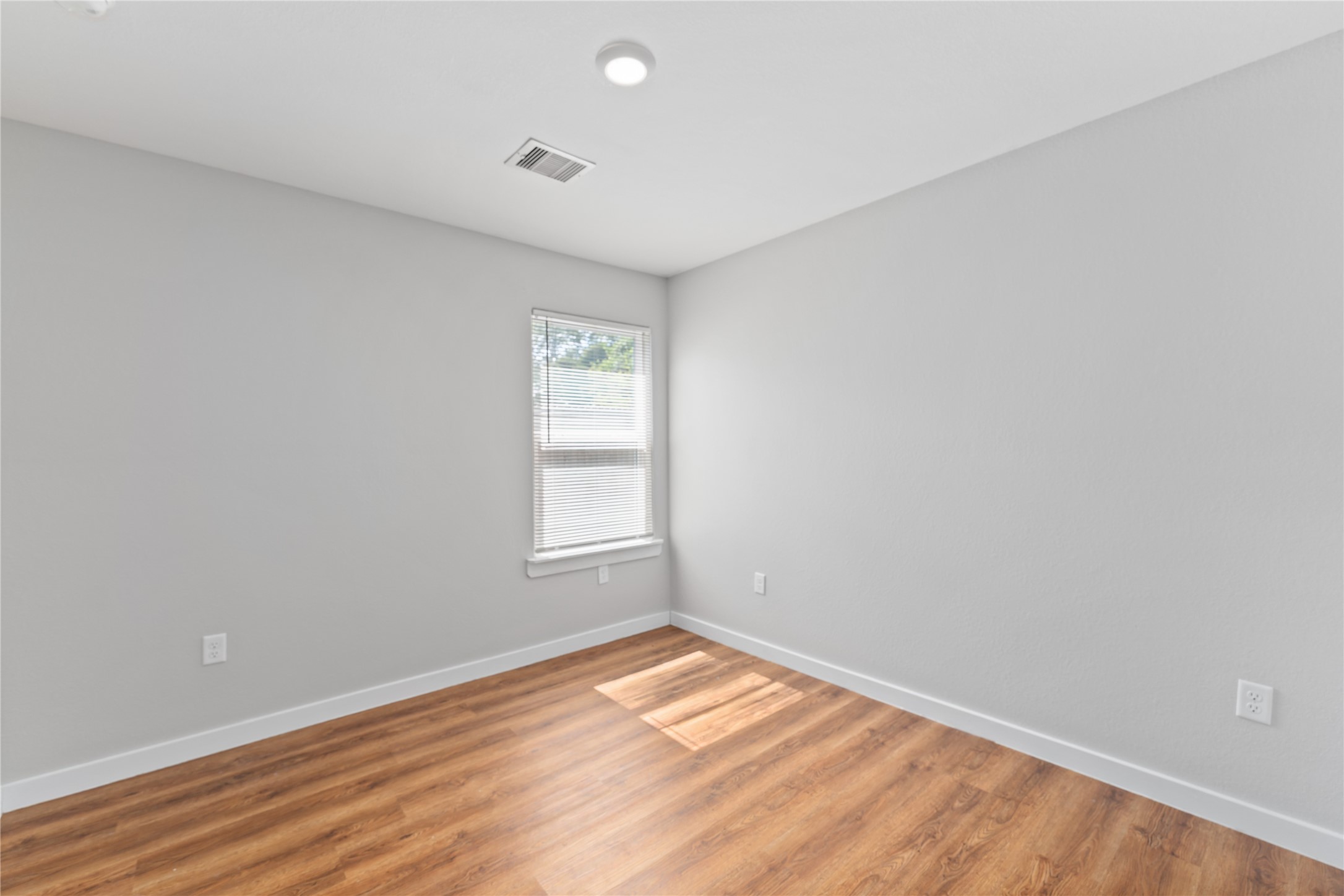 8617 Clarington Street Houston, TX 77016 - Photo 18 of 25 an empty room with wooden floor and windows