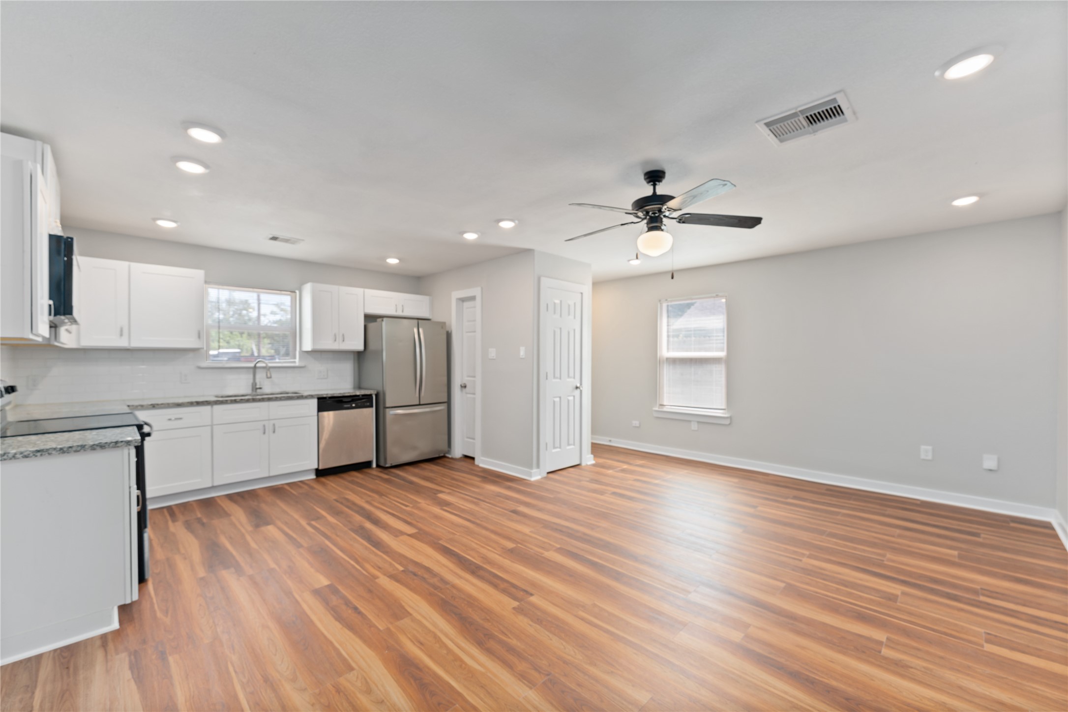 8617 Clarington Street Houston, TX 77016 - Photo 4 of 25 a large kitchen with stainless steel appliances granite countertop a sink window and a refrigerator