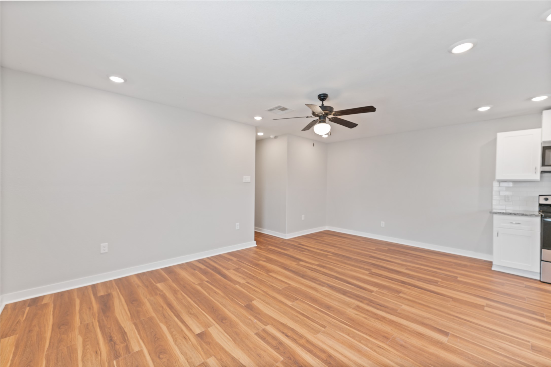 8617 Clarington Street Houston, TX 77016 - Photo 6 of 25 a view of empty room with wooden floor and fan
