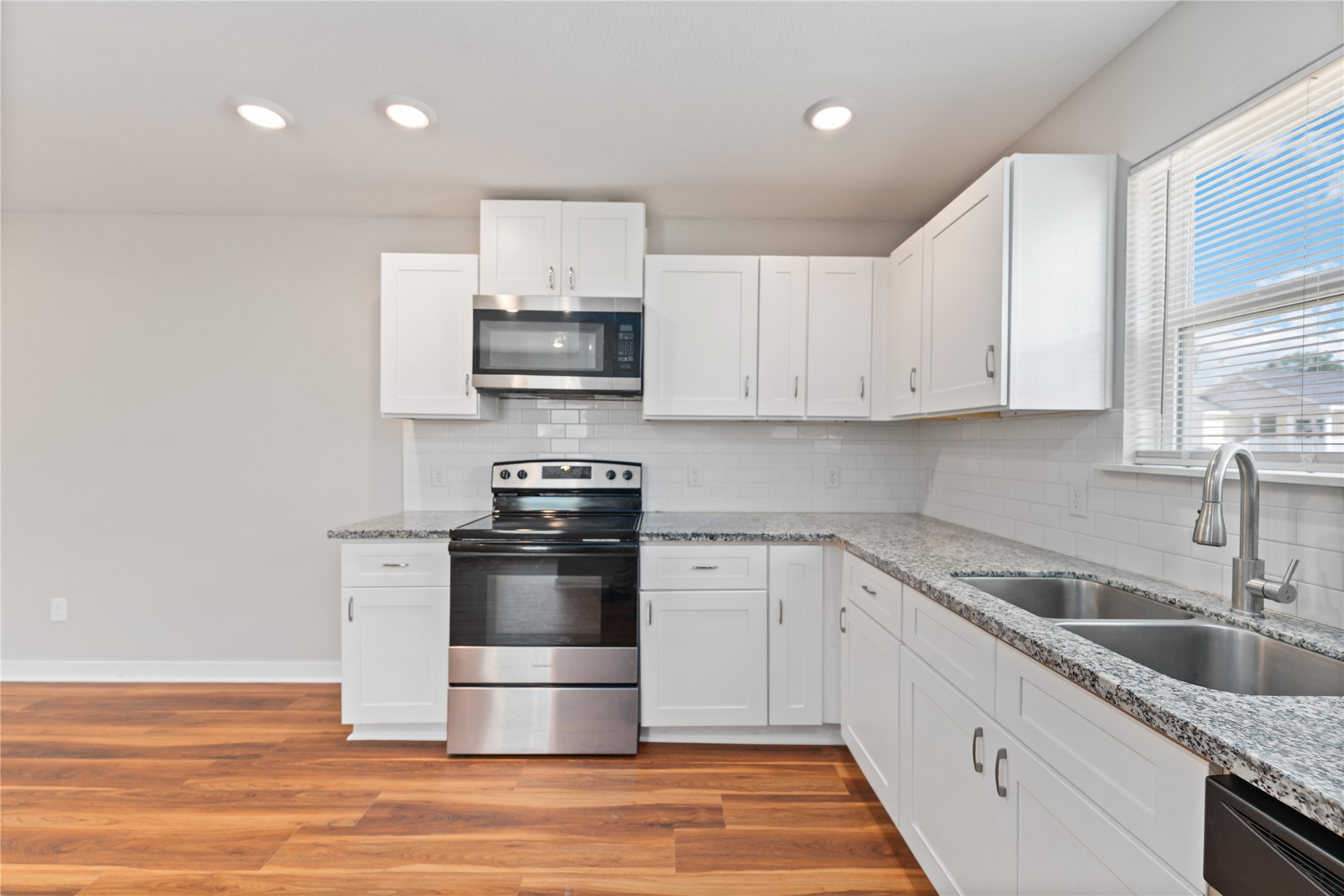 8617 Clarington Street Houston, TX 77016 - Photo 10 of 25 a kitchen with stainless steel appliances granite countertop a sink a stove a microwave and cabinets