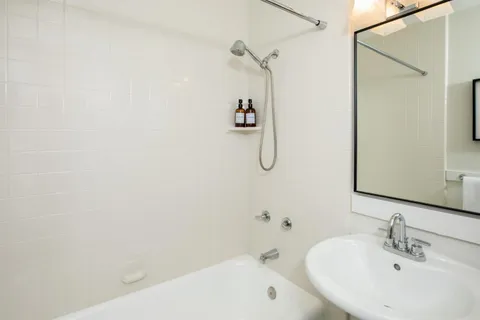 a bathroom with a bath tub with a mirror