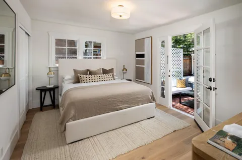 a bedroom with a bed wooden floor and window