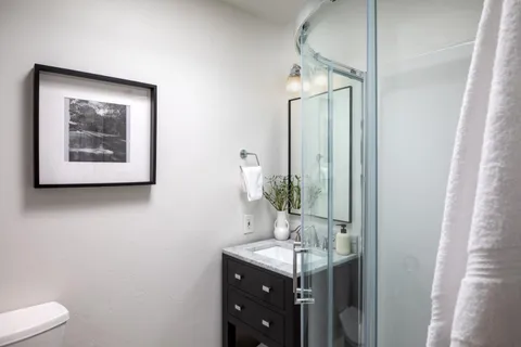 a bathroom with a toilet a sink and mirror