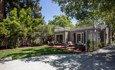 a front view of a house with garden and sitting area