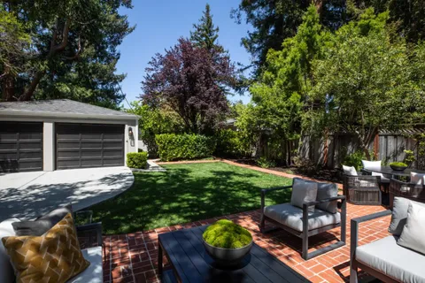 a view of backyard with outdoor seating and green space