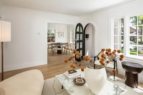 a view of a dining room with furniture one side and wooden floor