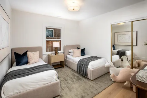 a bedroom with two beds and a large mirror