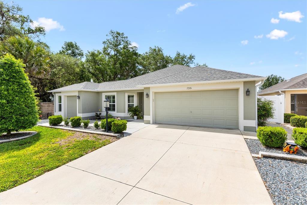 7351 Southeast 169th Cote Loop The Villages, FL 32162 - Photo 2 of 32 a front view of a house with yard and green space