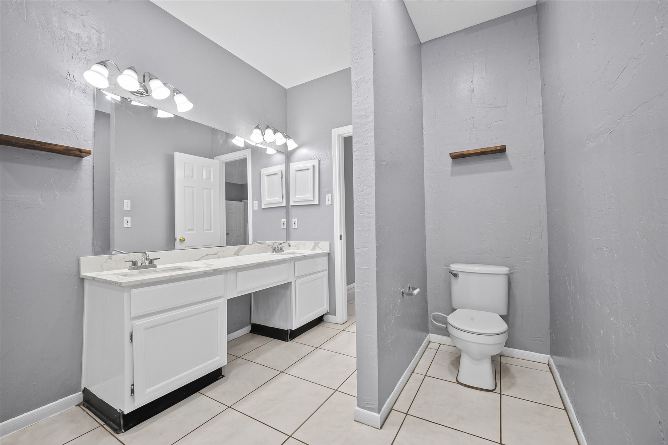 13607 Sable Lane Houston, TX 77014 - Photo 30 of 46 a spacious bathroom with a toilet sink and mirror