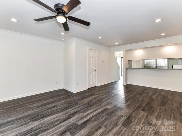 a view of a livingroom with a ceiling fan and wooden floor