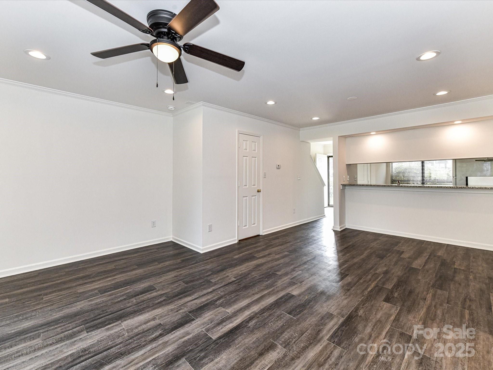 11020 Carmel Crossing Road Charlotte, NC 28226 - Photo 12 of 30 a view of a livingroom with a ceiling fan and wooden floor