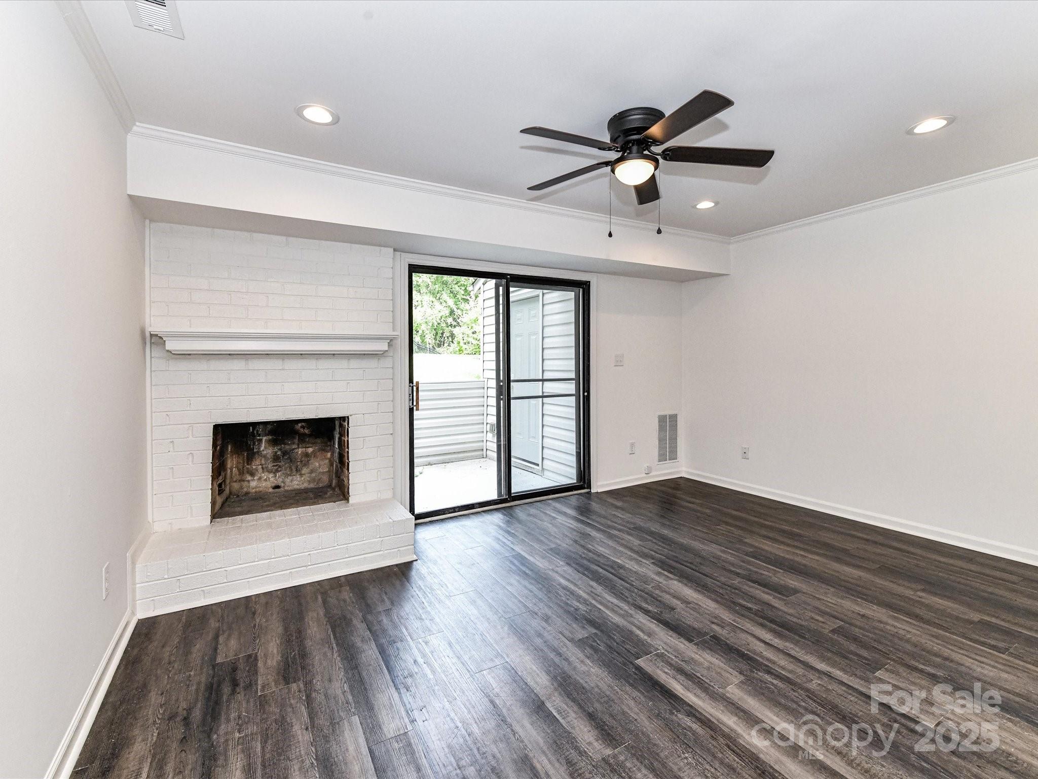 11020 Carmel Crossing Road Charlotte, NC 28226 - Photo 16 of 30 a view of an empty room with wooden floor fireplace and a window