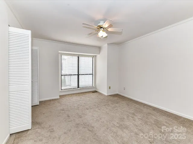 an empty room with windows and fan