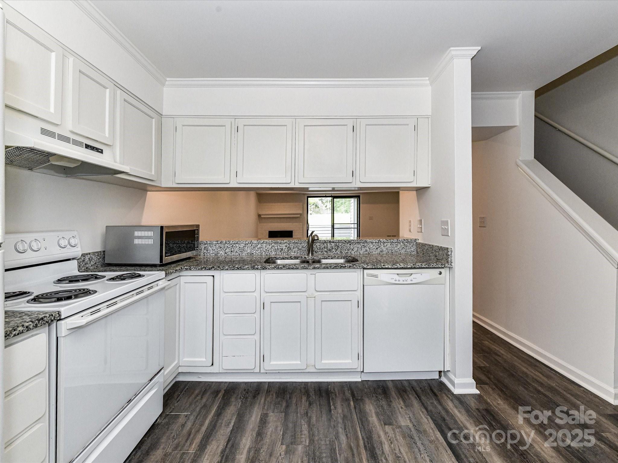 11020 Carmel Crossing Road Charlotte, NC 28226 - Photo 10 of 30 a kitchen with granite countertop white cabinets and white appliances