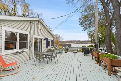 a view of a balcony with chairs and wooden floor