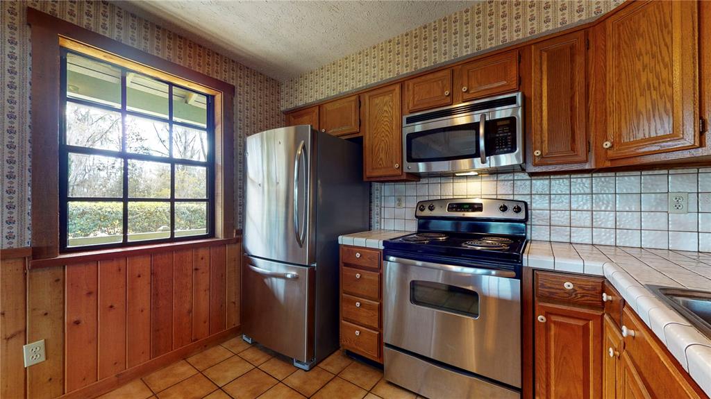 19803 Reading Road Lutz, FL 33558 - Photo 27 of 48 a kitchen with stainless steel appliances granite countertop a refrigerator stove and microwave