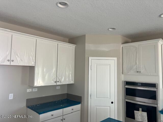 233 Bermudez Way St. Augustine, FL 32095 - Photo 4 of 12 a kitchen with granite countertop white cabinets and stainless steel appliances
