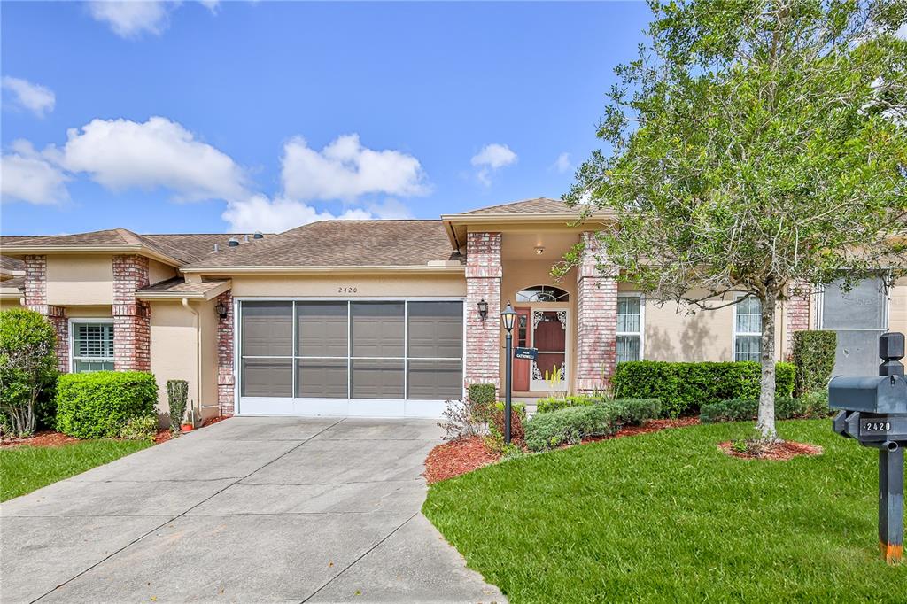 2420 Rolling View Drive Spring Hill, FL 34606 - Photo 2 of 62 a front view of a house with a yard and garage