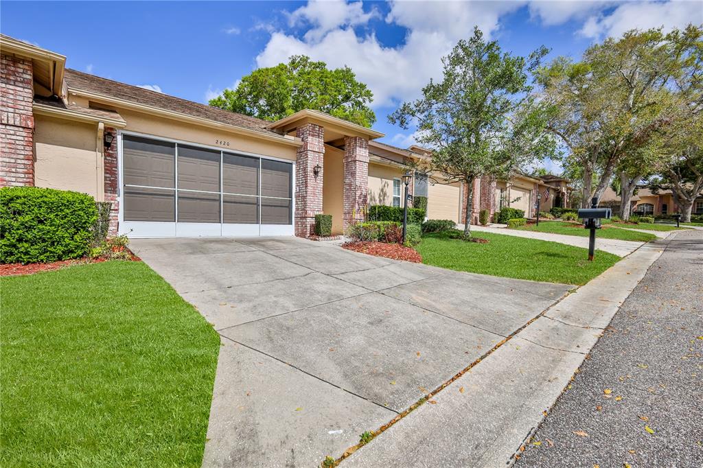 2420 Rolling View Drive Spring Hill, FL 34606 - Photo 3 of 62 front view of a house with a yard and an trees
