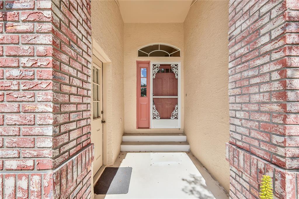2420 Rolling View Drive Spring Hill, FL 34606 - Photo 4 of 62 a view of a hallway with a black white checkered floor and a large window
