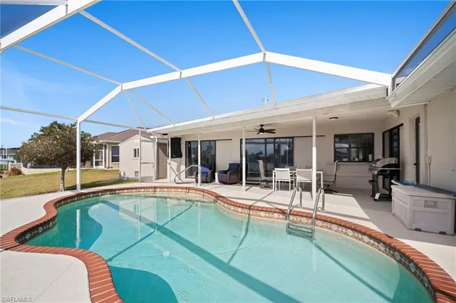 a view of a patio with table and chairs under an umbrella